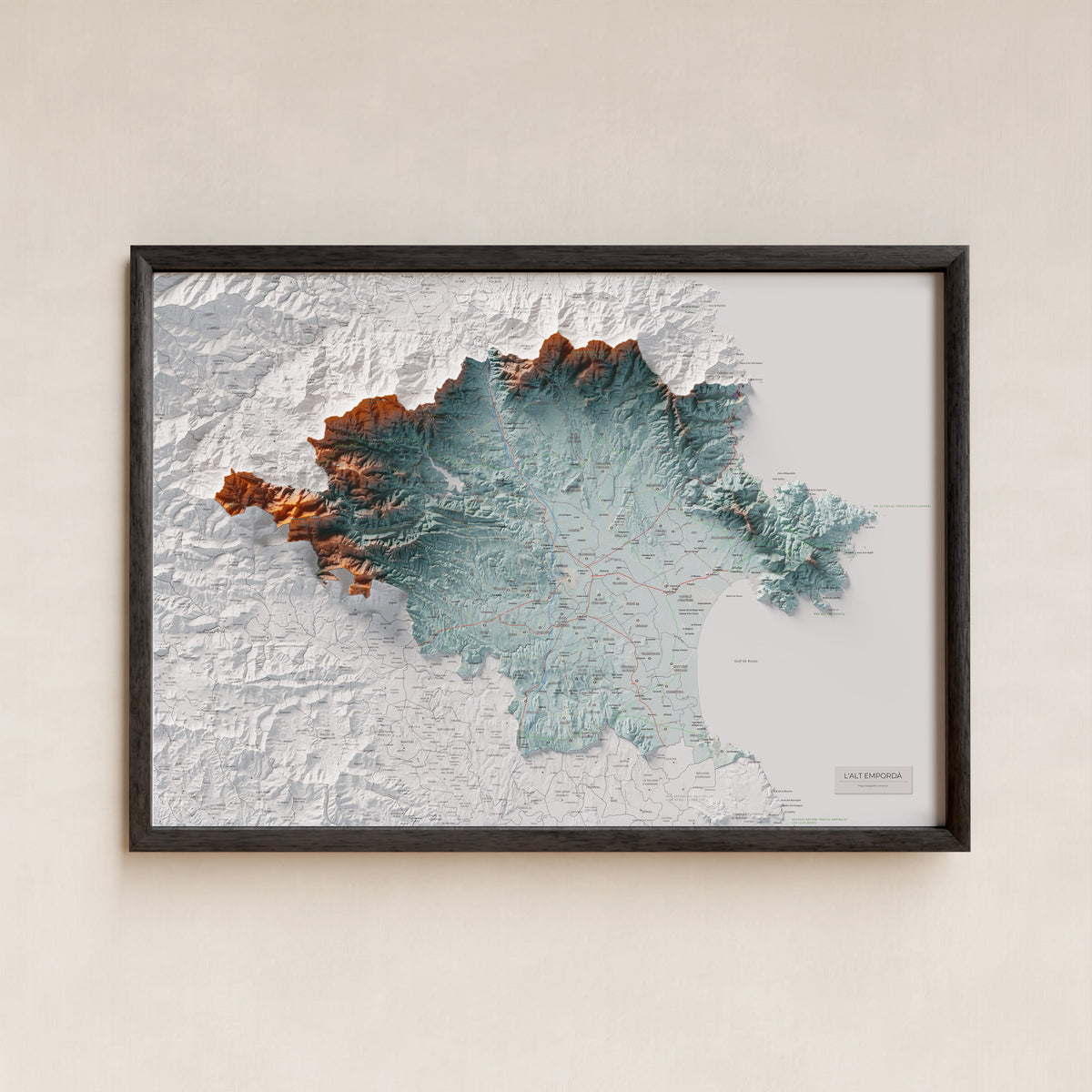 Mapa de relleu de l’Alt Empordà, amb el territori en color i l’entorn en blanc. Presentació amb marc. 70 × 100 cm. Estil Blau i taronja.
