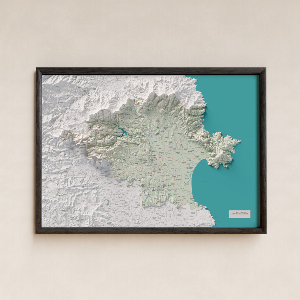 Mapa de relleu de l’Alt Empordà, amb el territori en color i l’entorn en blanc. Presentació amb marc. 70 × 100 cm. Estil Cartogràfic.
