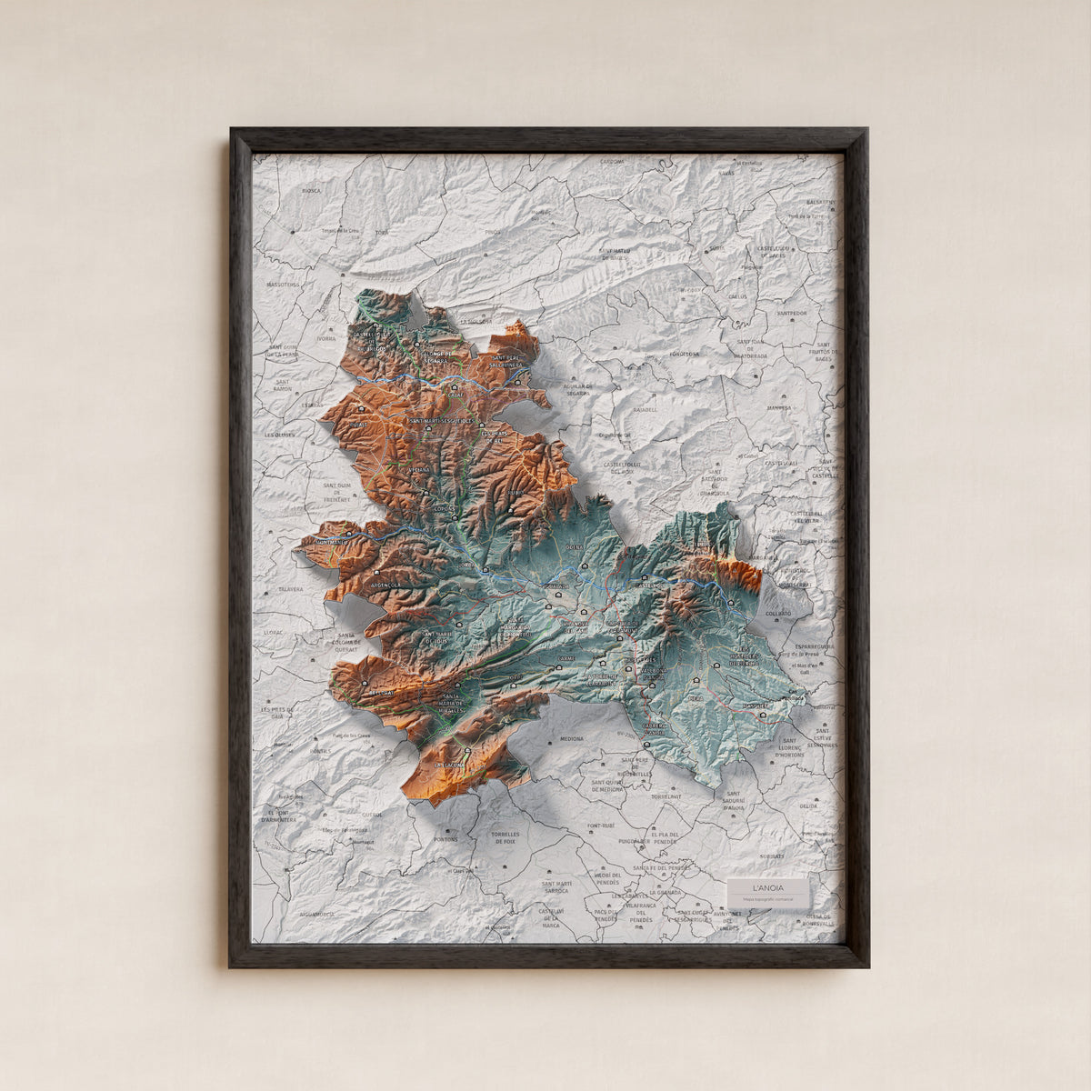 Mapa de relleu de l’Anoia, amb el territori en color i l’entorn en blanc. Presentació amb marc. 30 × 40 cm. Estil Blau i taronja.