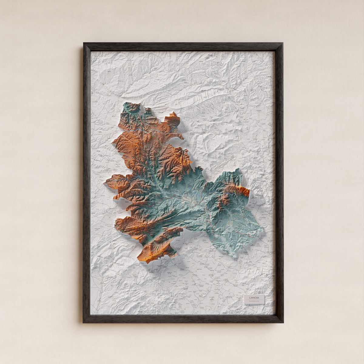 Mapa de relleu de l’Anoia, amb el territori en color i l’entorn en blanc. Presentació amb marc. 70 × 100 cm. Estil Blau i taronja.