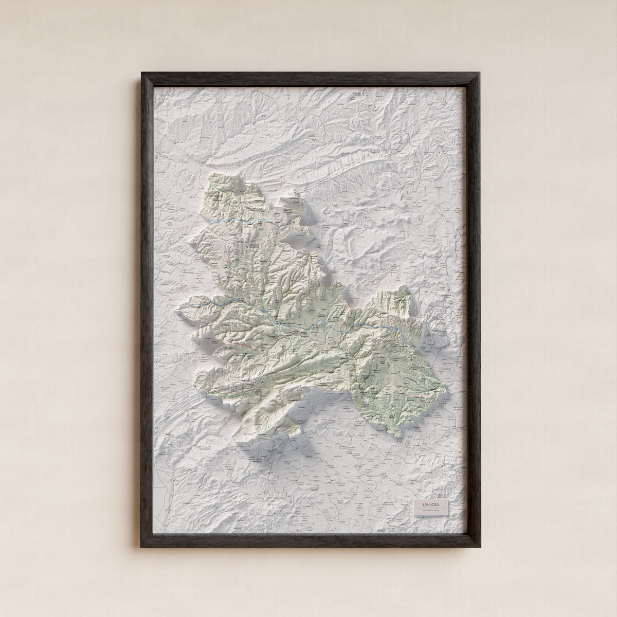 Mapa de relleu de l’Anoia, amb el territori en color i l’entorn en blanc. Presentació amb marc. 70 × 100 cm. Estil Cartogràfic.