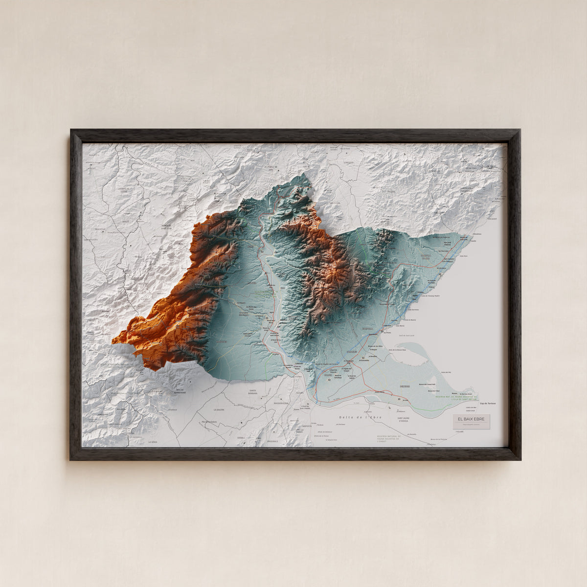 Mapa de relieve del Baix Ebre, con el territorio en color y el entorno en blanco. Presentación con marco. 50 × 70 cm. Estilo Azul y naranja.