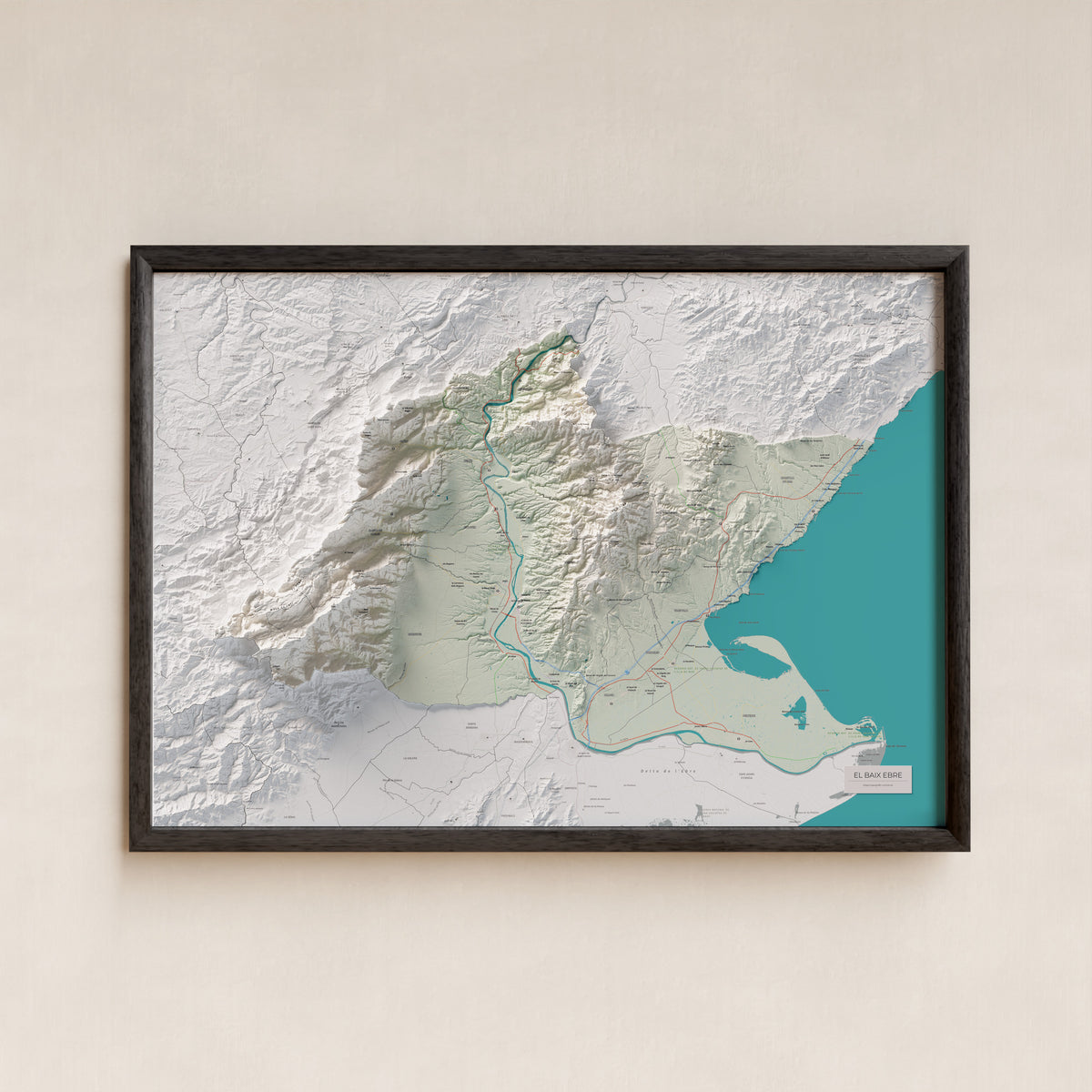 Mapa de relieve del Baix Ebre, con el territorio en color y el entorno en blanco. Presentación con marco. 70 × 100 cm. Estilo Cartográfico.
