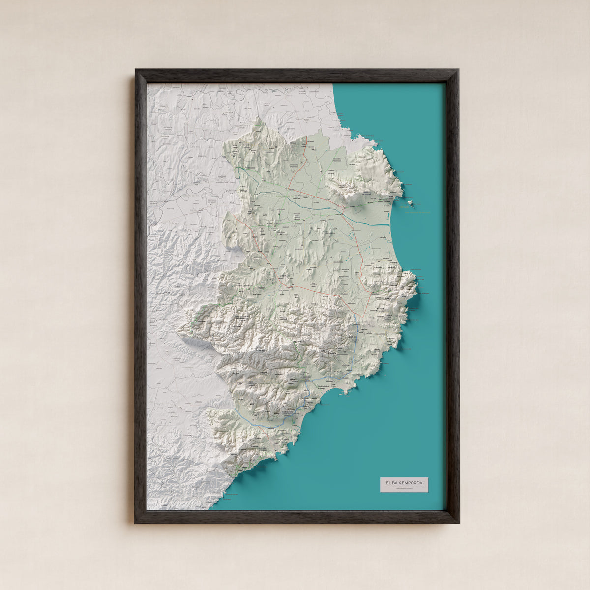 Mapa de relieve del Baix Empordà, con el territorio en color y el entorno en blanco. Presentación con marco. 70 × 100 cm. Estilo Cartográfico.