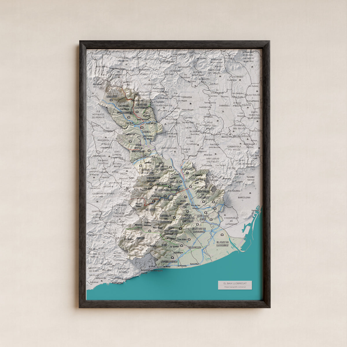 Mapa de relleu del Baix Llobregat, amb el territori en color i l’entorn en blanc. Presentació amb marc. 21 × 30 cm. Estil Cartogràfic.