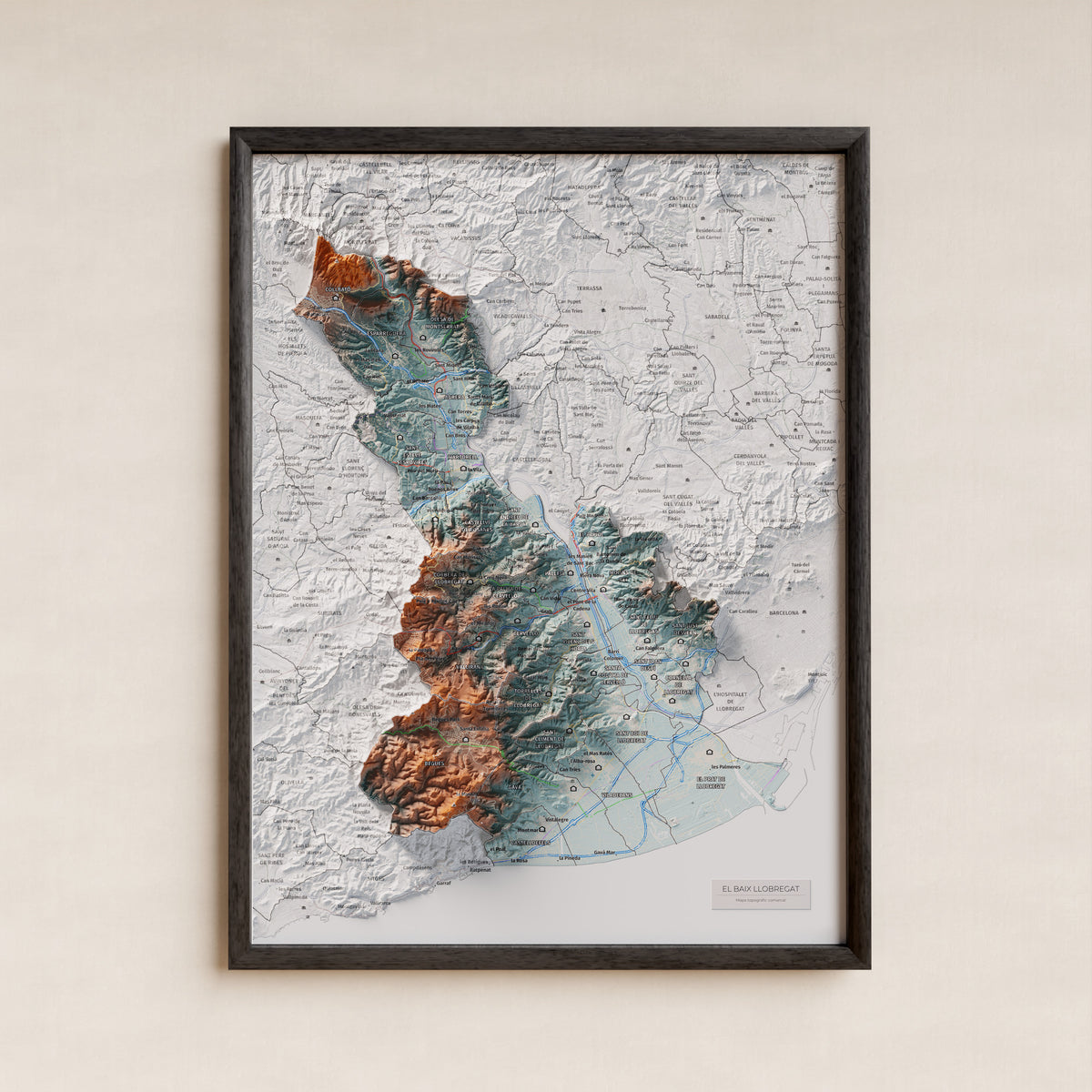 Mapa de relleu del Baix Llobregat, amb el territori en color i l’entorn en blanc. Presentació amb marc. 30 × 40 cm. Estil Blau i taronja.