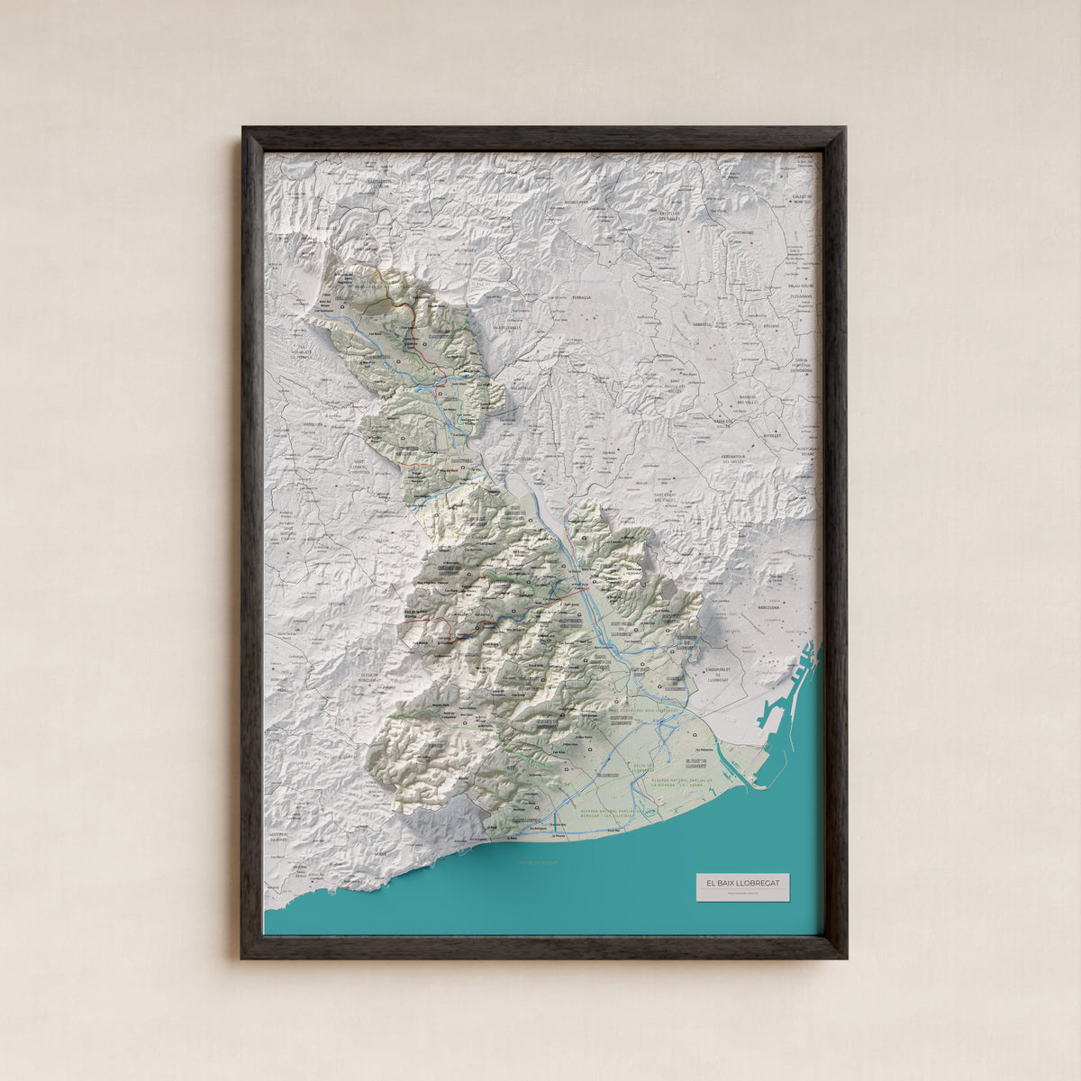 Mapa de relleu del Baix Llobregat, amb el territori en color i l’entorn en blanc. Presentació amb marc. 50 × 70 cm. Estil Cartogràfic.