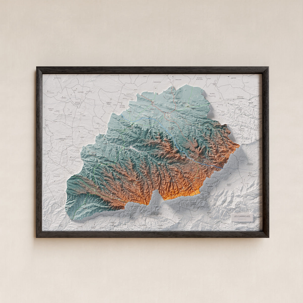 Mapa de relieve de las Garrigues, con el territorio en color y el entorno en blanco. Presentación con marco. 50 × 70 cm. Estilo Azul y naranja.