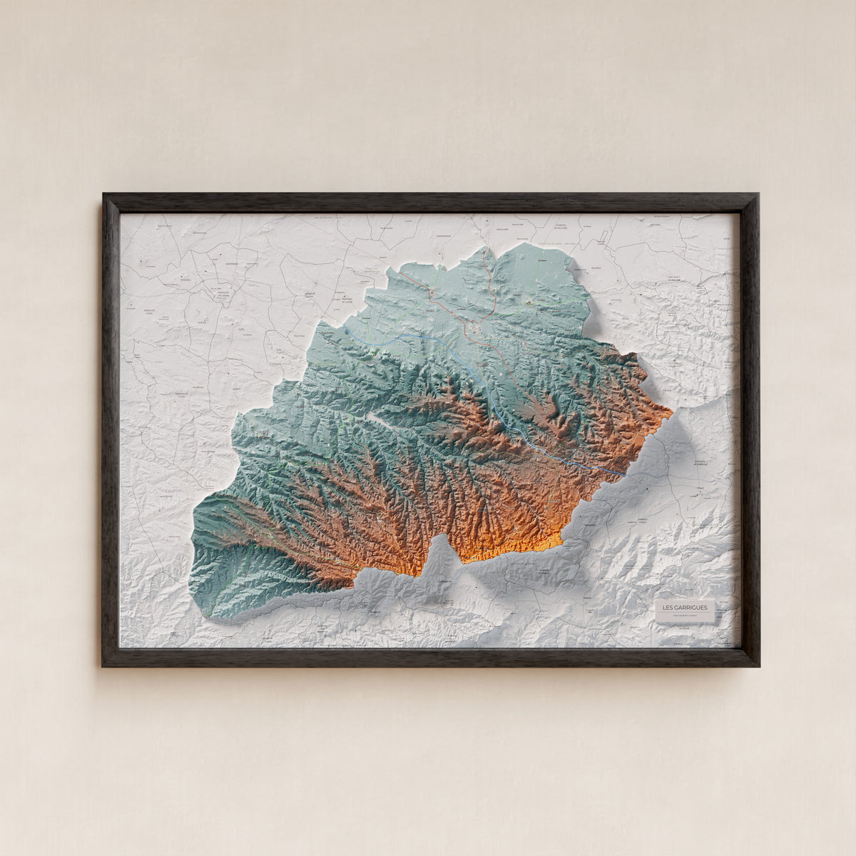 Mapa de relieve de las Garrigues, con el territorio en color y el entorno en blanco. Presentación con marco. 70 × 100 cm. Estilo Azul y naranja.