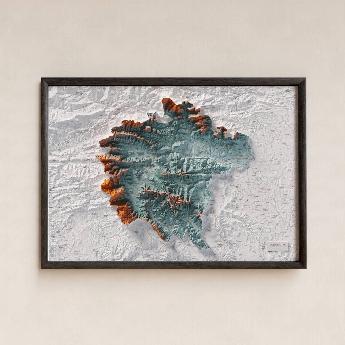 Mapa de relleu de la Garrotxa, amb el territori en color i l’entorn en blanc. Presentació amb marc. 70 × 100 cm. Estil Blau i taronja.