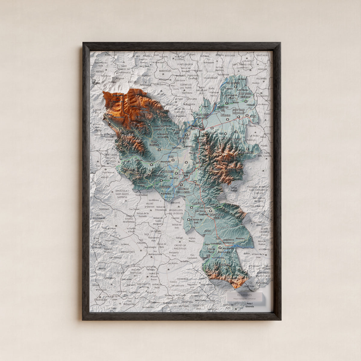 Mapa de relleu del Gironès, amb el territori en color i l’entorn en blanc. Presentació amb marc. 21 × 30 cm. Estil Blau i taronja.