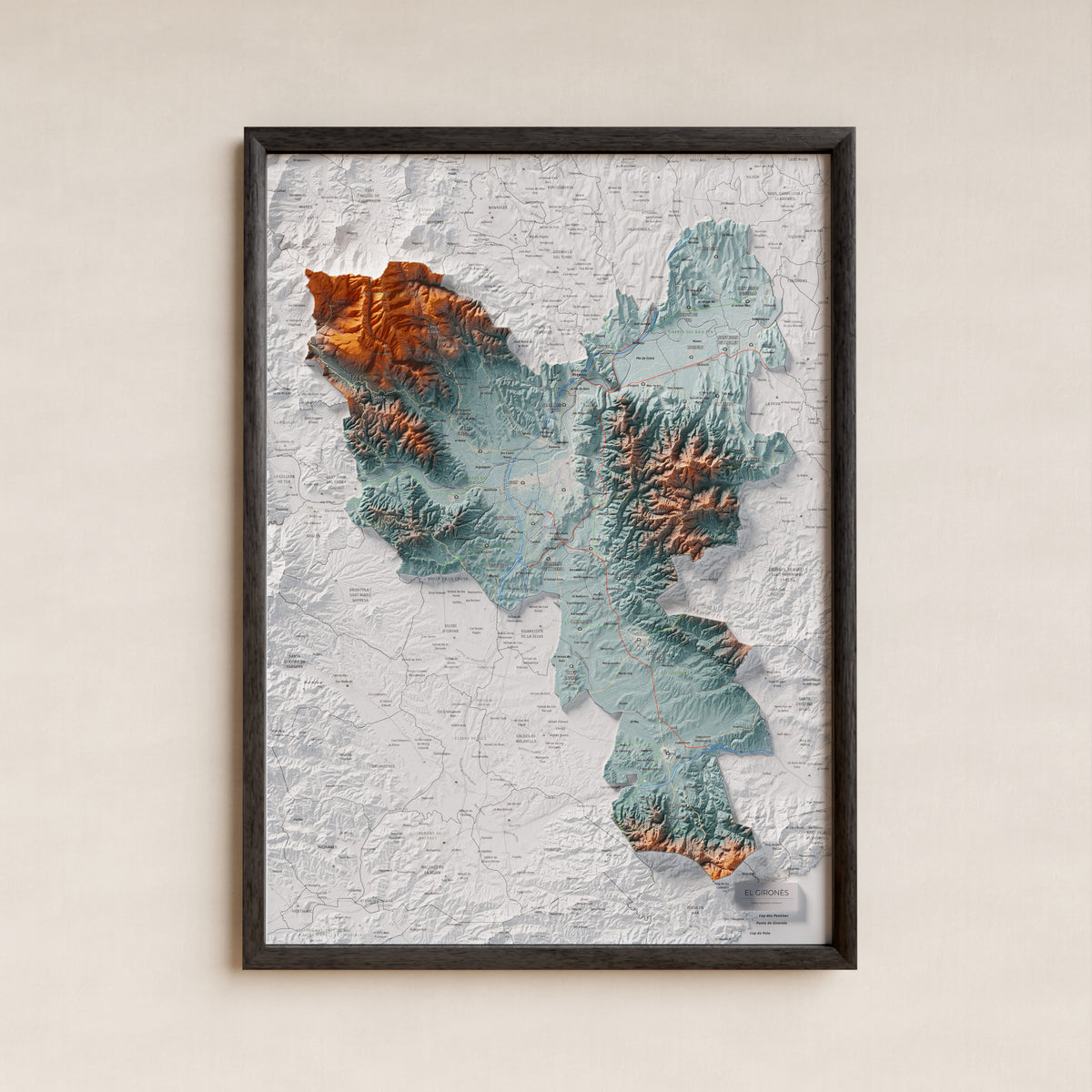 Mapa de relleu del Gironès, amb el territori en color i l’entorn en blanc. Presentació amb marc. 50 × 70 cm. Estil Blau i taronja.