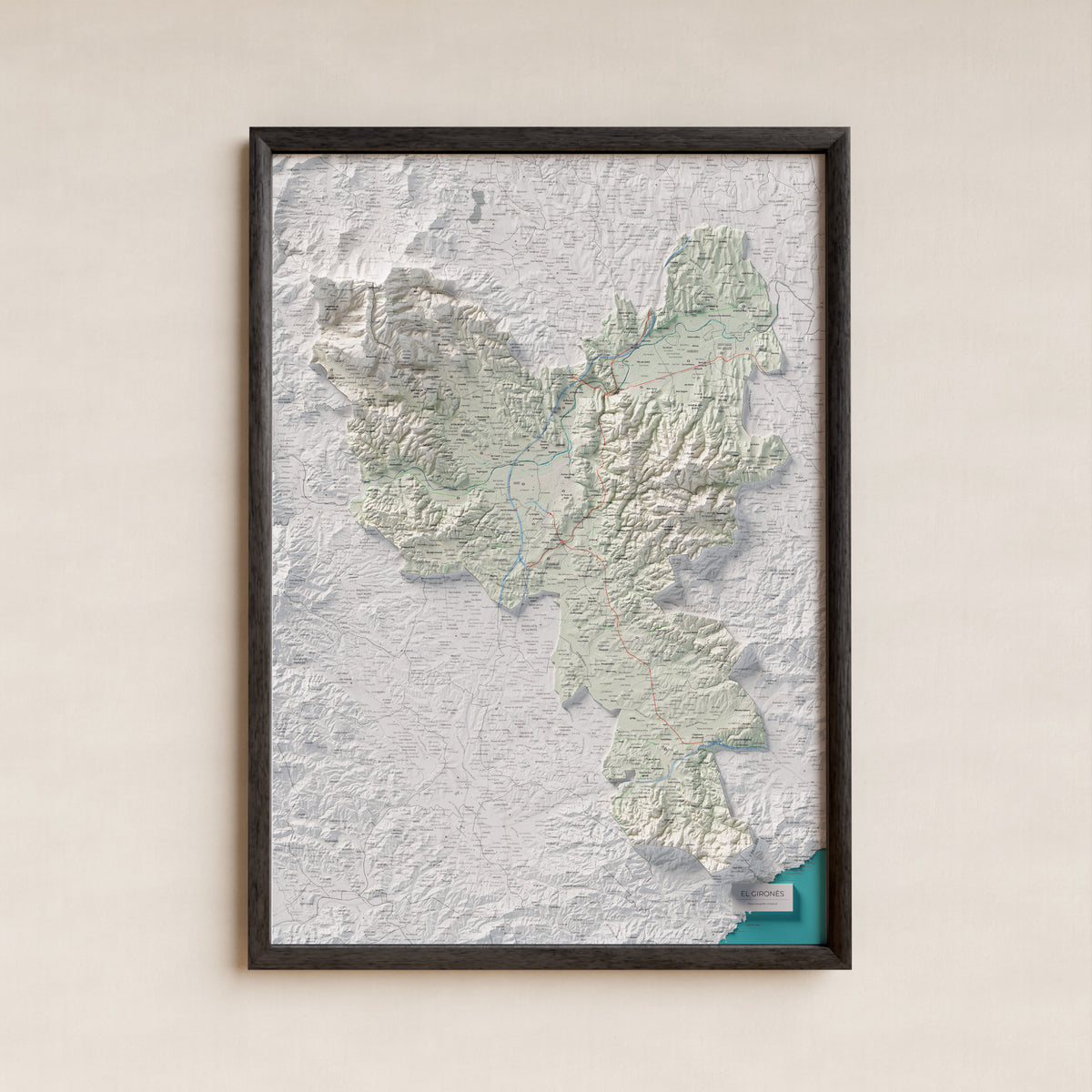 Mapa de relleu del Gironès, amb el territori en color i l’entorn en blanc. Presentació amb marc. 70 × 100 cm. Estil Cartogràfic.