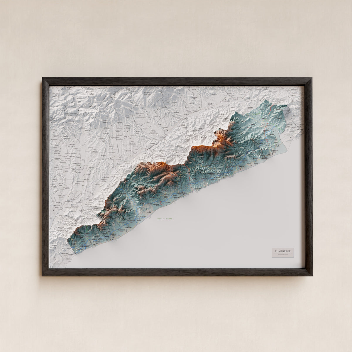 Mapa de relleu del Maresme, amb el territori en color i l’entorn en blanc. Presentació amb marc. 50 × 70 cm. Estil Blau i taronja.