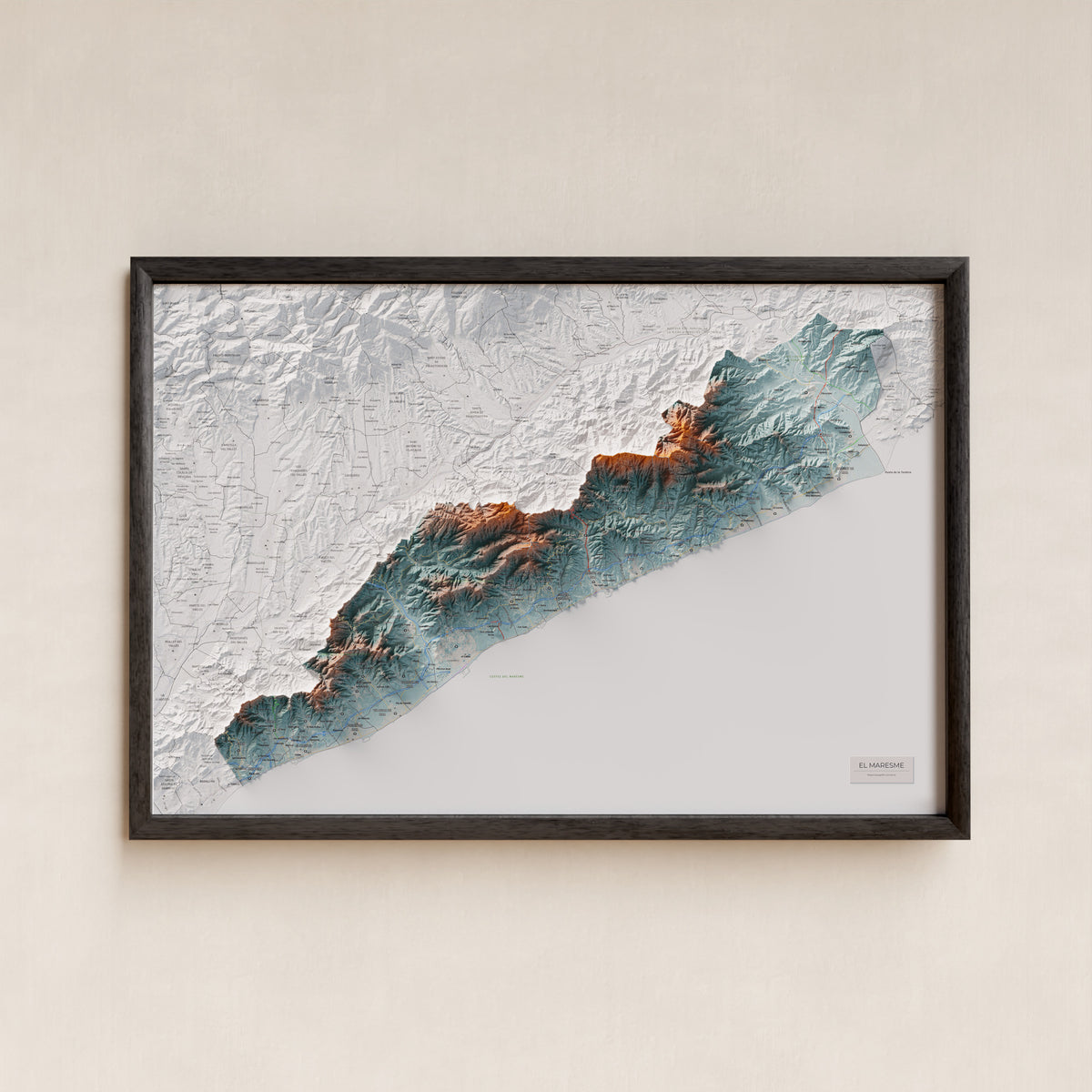 Mapa de relleu del Maresme, amb el territori en color i l’entorn en blanc. Presentació amb marc. 61 × 91 cm. Estil Blau i taronja.