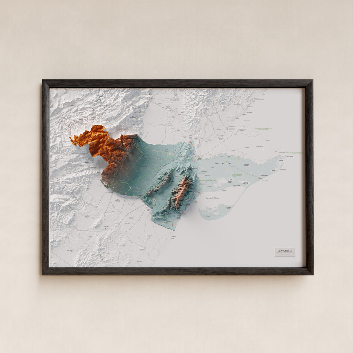 Mapa de relieve del Montsià, con el territorio en color y el entorno en blanco. Presentación con marco. 70 × 100 cm. Estilo Azul y naranja.