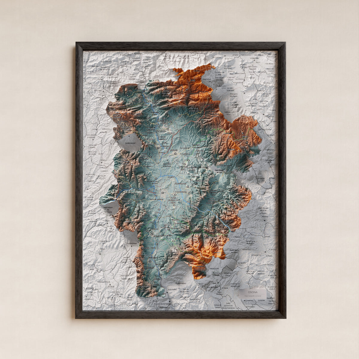 Mapa de relieve de Osona, con el territorio en color y el entorno en blanco. Presentación con marco. 30 × 40 cm. Estilo Azul y naranja.
