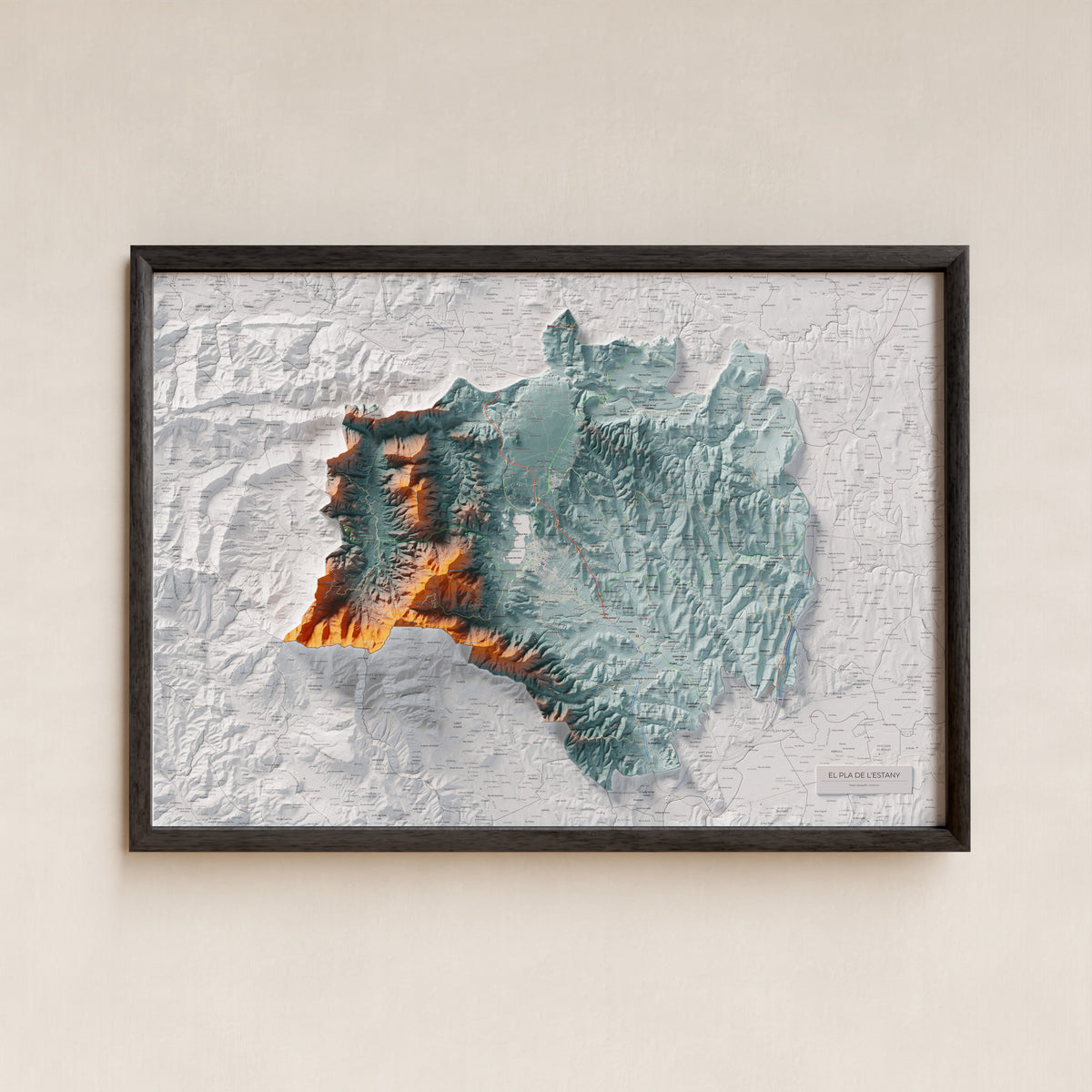 Mapa de relleu del Pla de l’Estany, amb el territori en color i l’entorn en blanc. Presentació amb marc. 70 × 100 cm. Estil Blau i taronja.