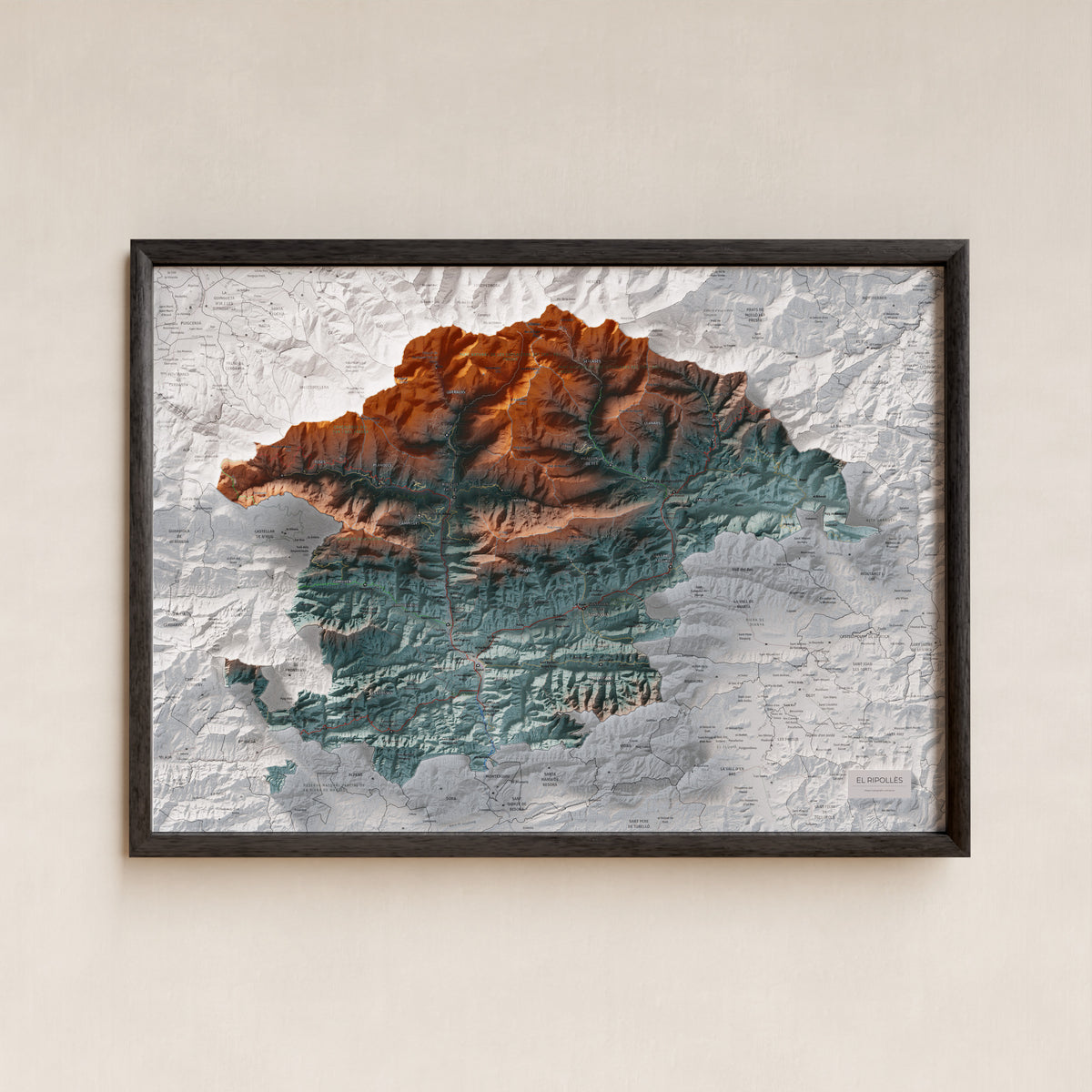 Mapa de relleu del Ripollès, amb el territori en color i l’entorn en blanc. Presentació amb marc. 50 × 70 cm. Estil Blau i taronja.