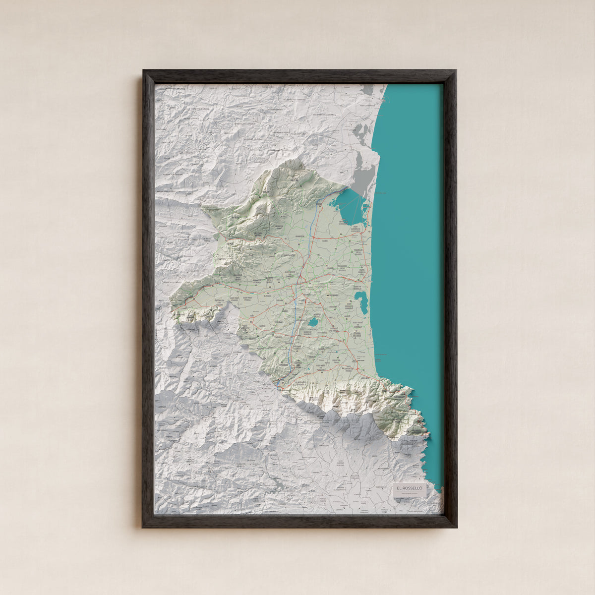 Mapa de relieve del Rosselló, con el territorio en color y el entorno en blanco. Presentación con marco. 61 × 91 cm. Estilo Cartográfico.