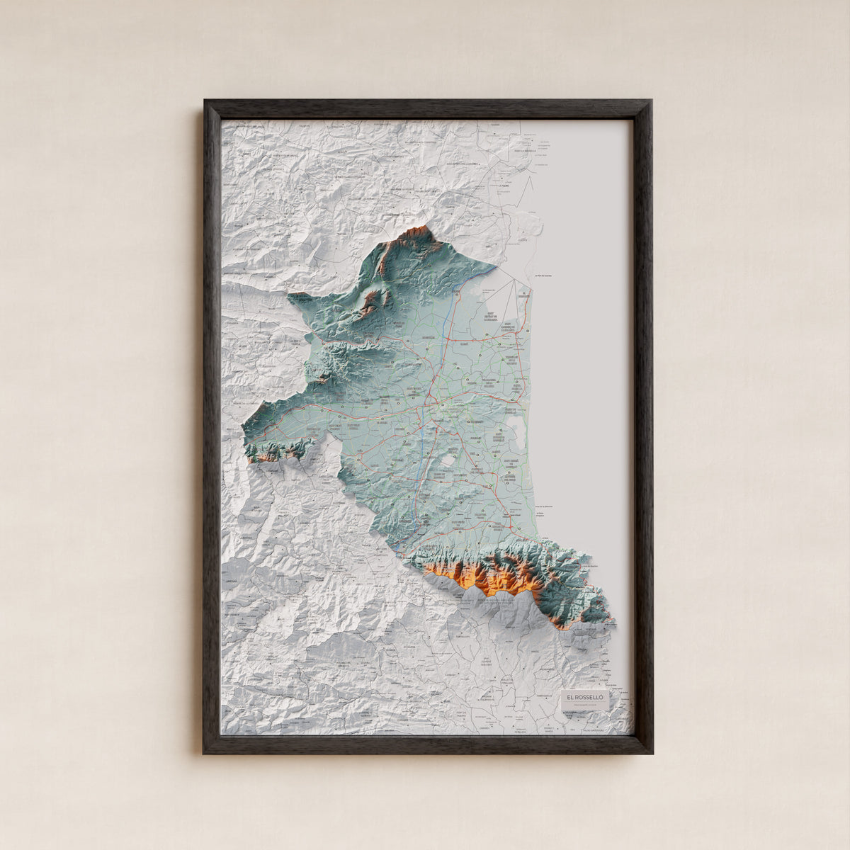 Mapa de relieve del Rosselló, con el territorio en color y el entorno en blanco. Presentación con marco. 61 × 91 cm. Estilo Azul y naranja.