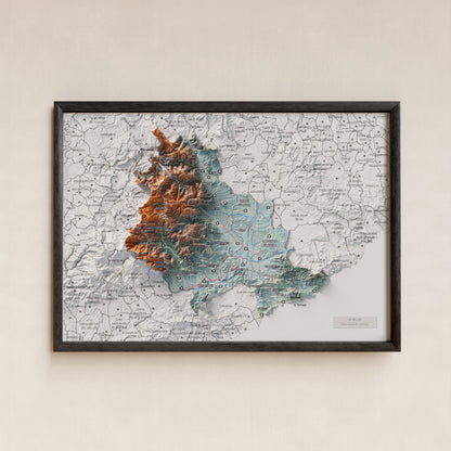 Mapa de relleu de la Selva, amb el territori en color i l’entorn en blanc. Presentació amb marc. 21 × 30 cm. Estil Blau i taronja.