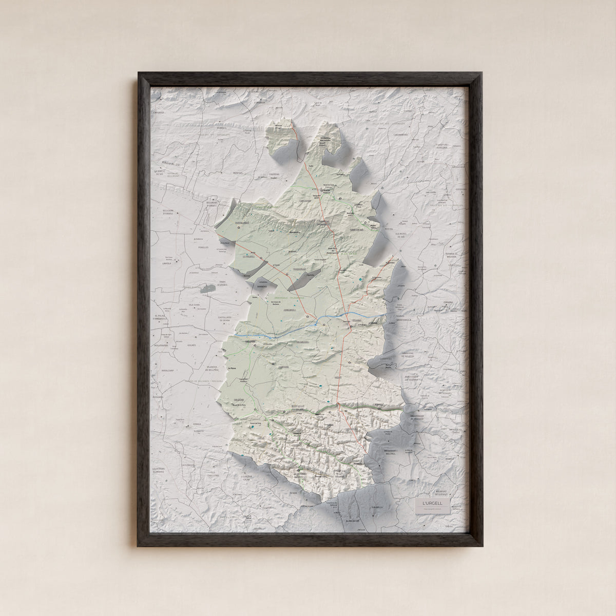 Mapa de relleu de l’Urgell, amb el territori en color i l’entorn en blanc. Presentació amb marc. 50 × 70 cm. Estil Cartogràfic.