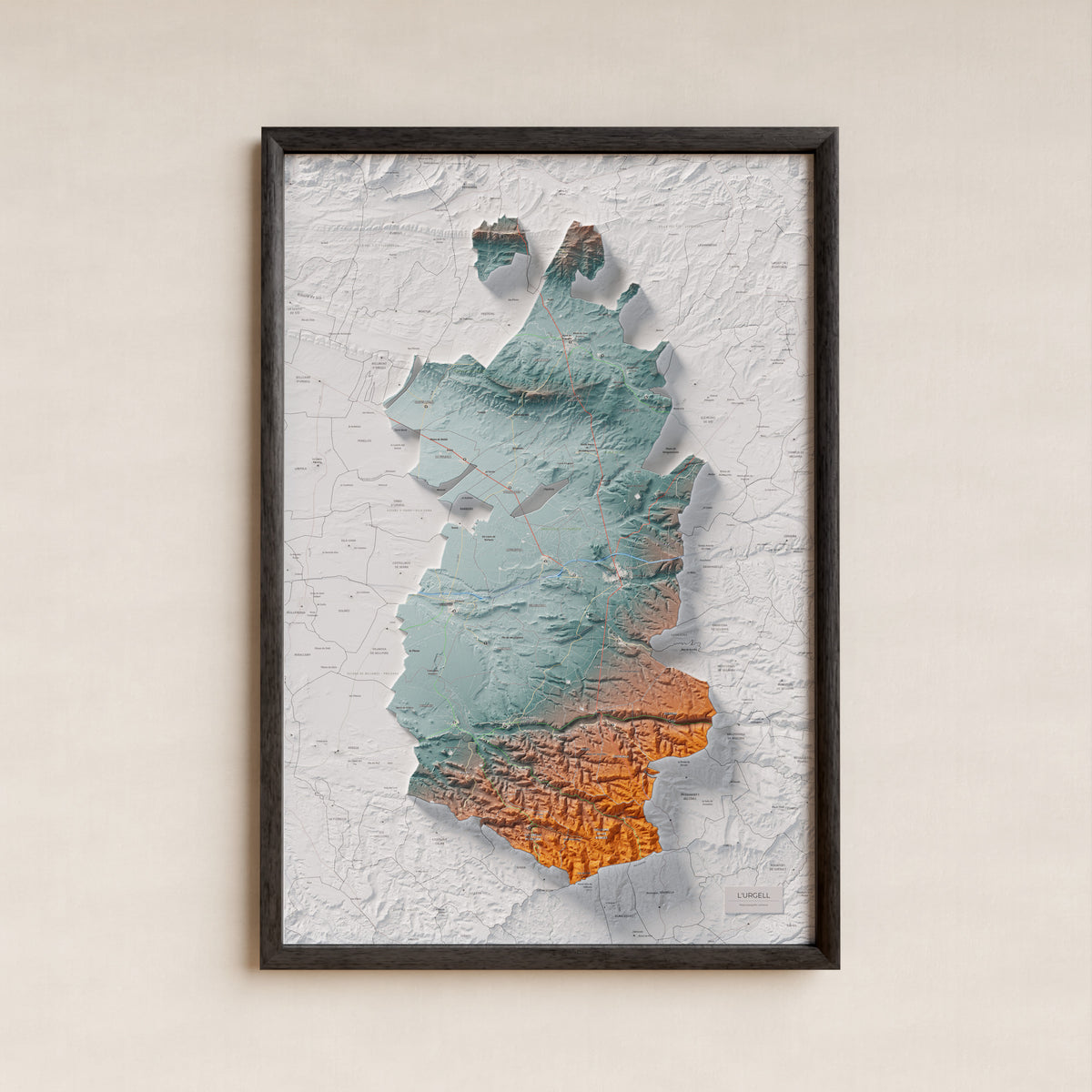 Mapa de relleu de l’Urgell, amb el territori en color i l’entorn en blanc. Presentació amb marc. 61 × 91 cm. Estil Blau i taronja.