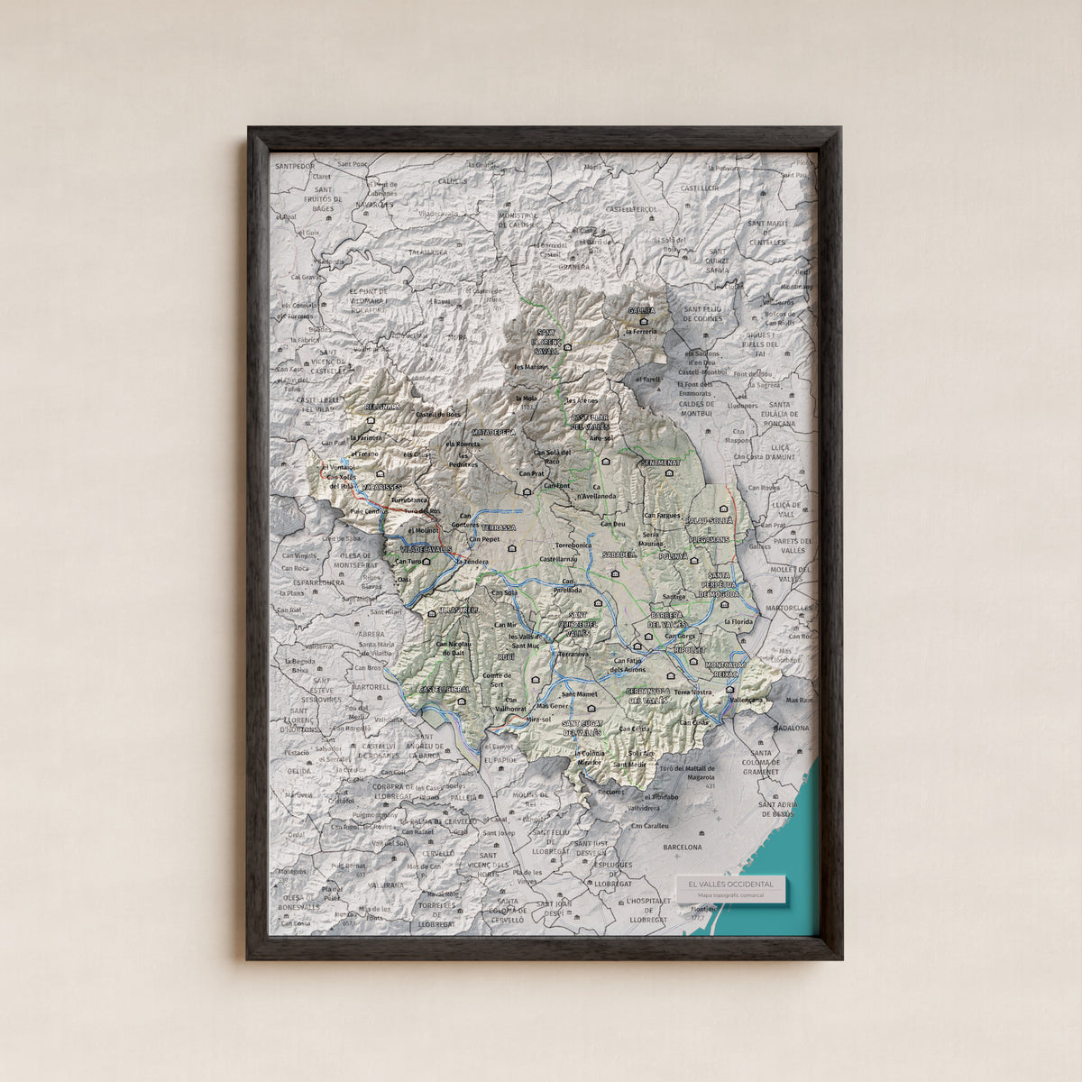 Mapa de relieve del Vallès Occidental, con el territorio en color y el entorno en blanco. Presentación con marco. 21 × 30 cm. Estilo Cartográfico.