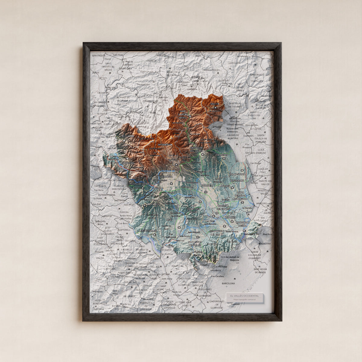Mapa de relieve del Vallès Occidental, con el territorio en color y el entorno en blanco. Presentación con marco. 21 × 30 cm. Estilo Azul y naranja.