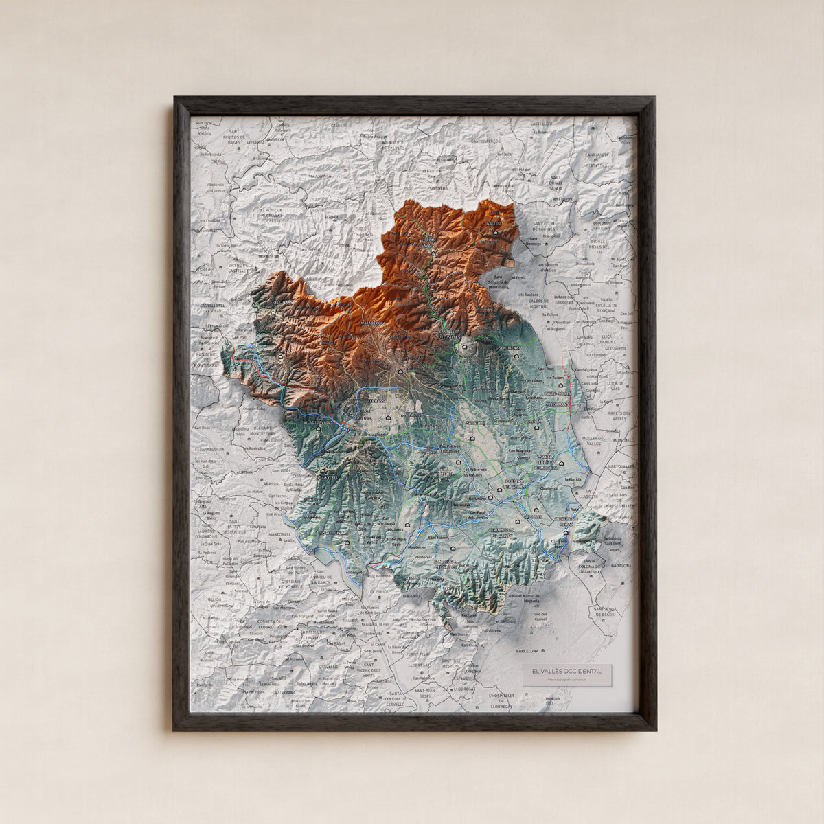 Mapa de relieve del Vallès Occidental, con el territorio en color y el entorno en blanco. Presentación con marco. 30 × 40 cm. Estilo Azul y naranja.
